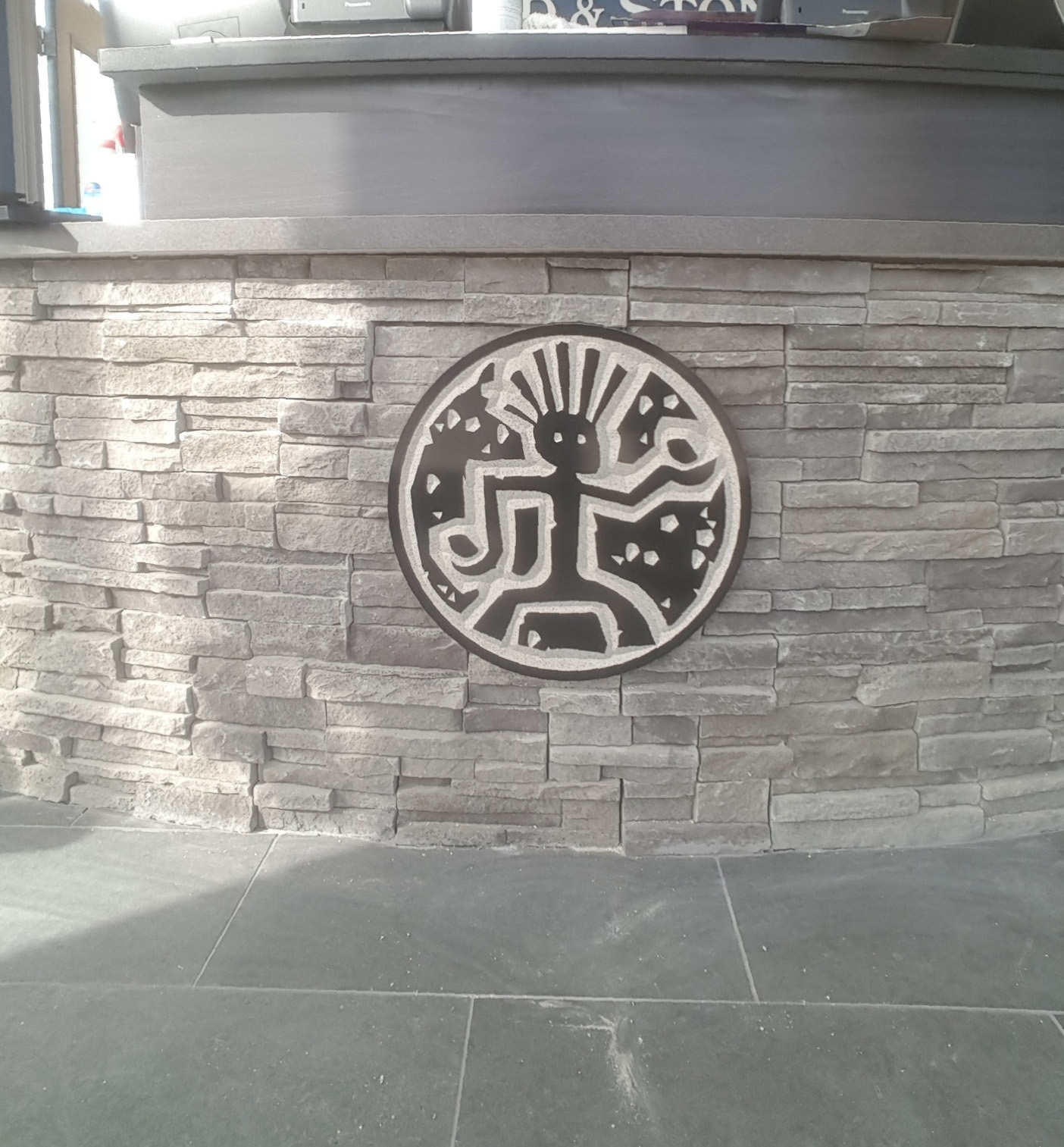Custom circular emblem mounted on a stone reception desk