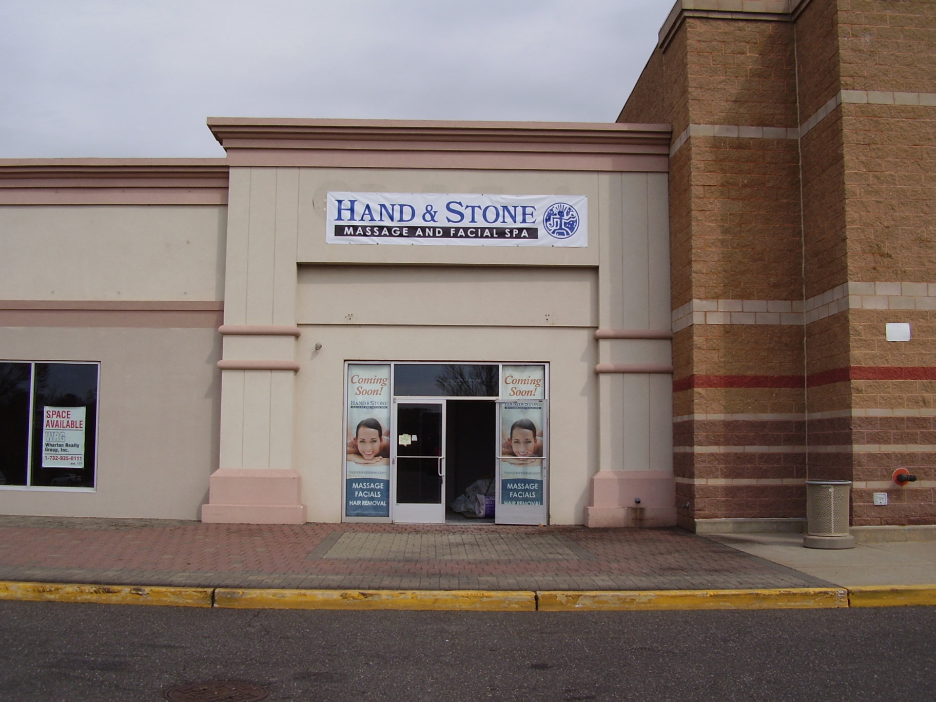 Hand and Stone exterior banner and coming soon window graphics